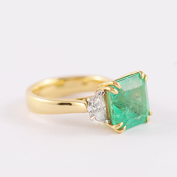 Emerald Cut Emerald ring with Trapezoid side Diamonds.