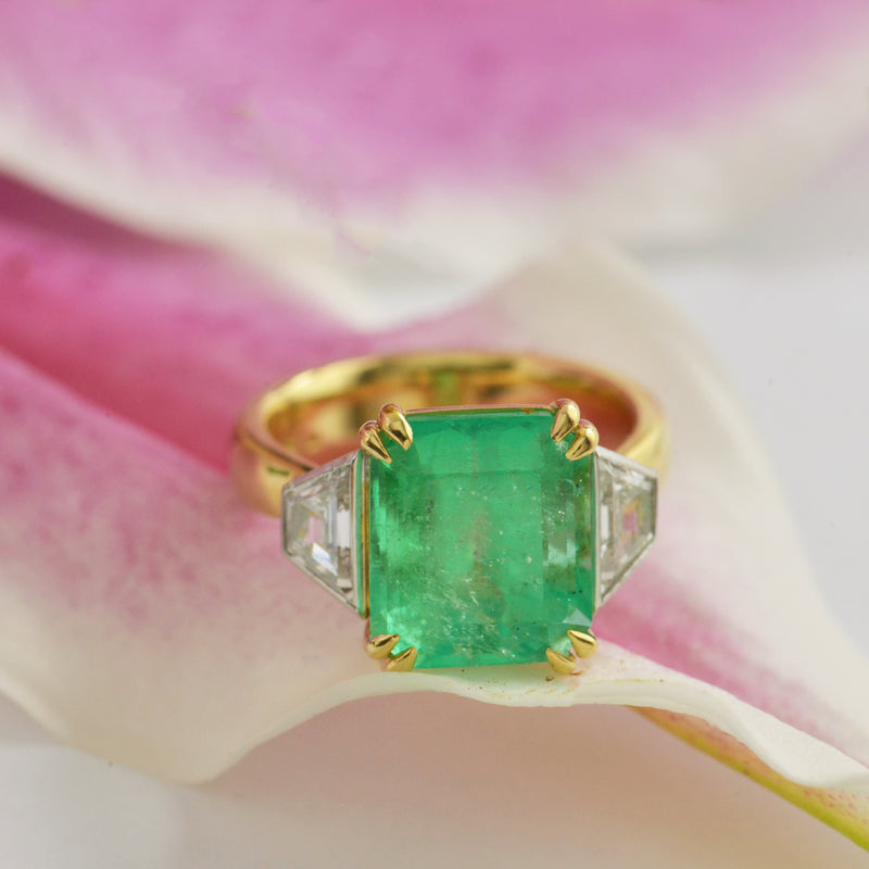 Emerald Cut Emerald ring with Trapezoid side Diamonds.