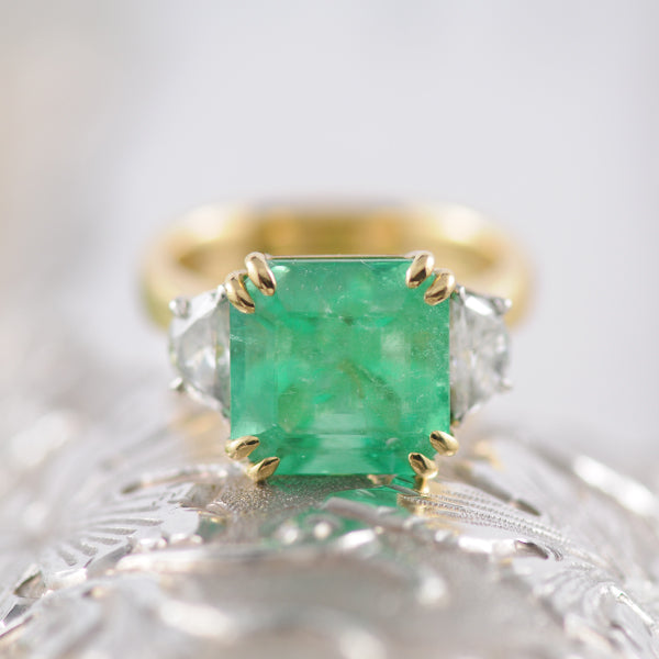 Emerald Cut Emerald ring with Trapezoid side Diamonds.